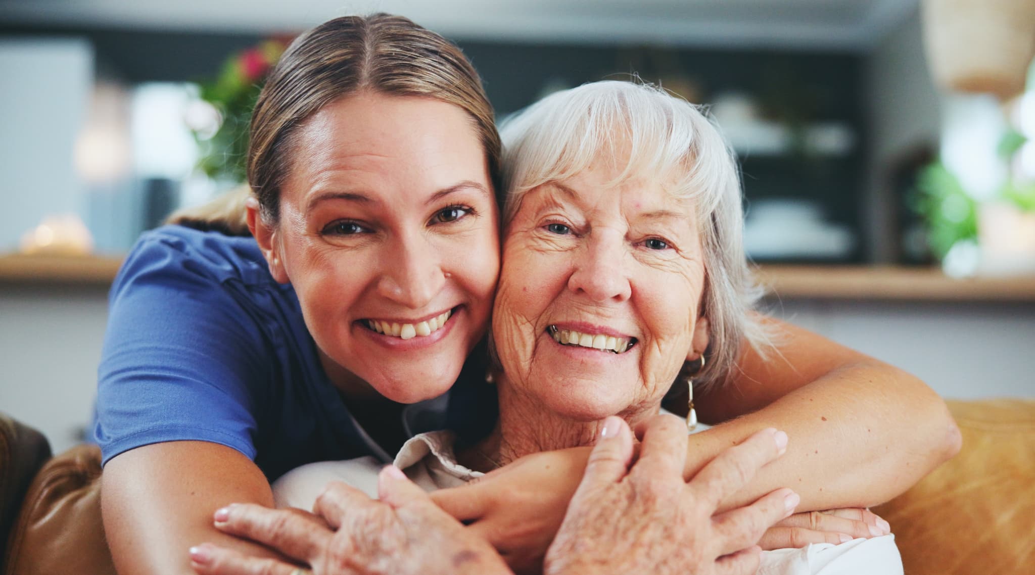 A daughter with her arm around her smiling mother at home